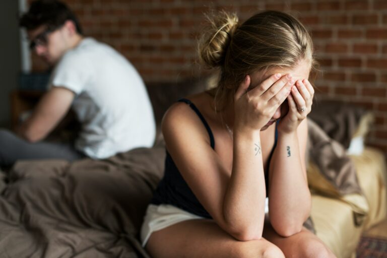 Woman lying awake beside her partner while questioning her loss of sexual desire and emotional intimacy