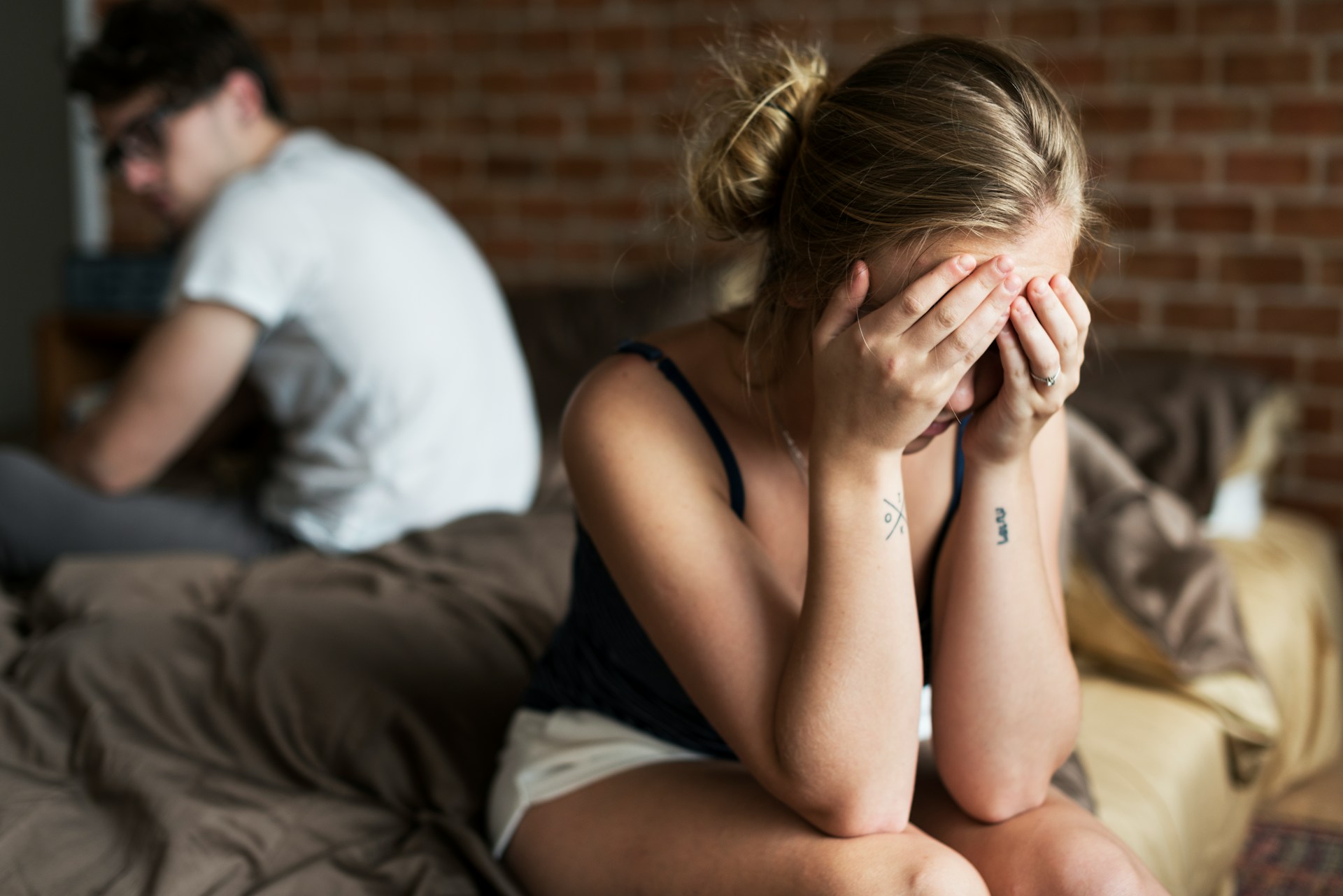 Woman lying awake beside her partner while questioning her loss of sexual desire and emotional intimacy
