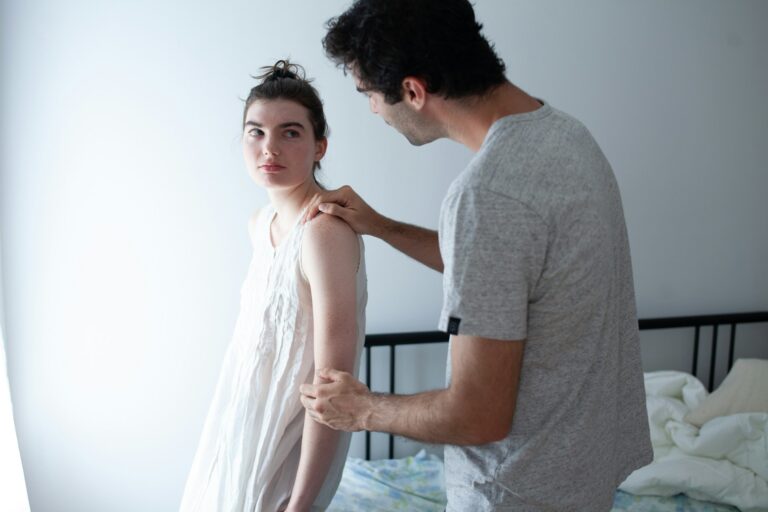 Woman looking emotionally distant as her partner reaches toward her during a tense relationship moment